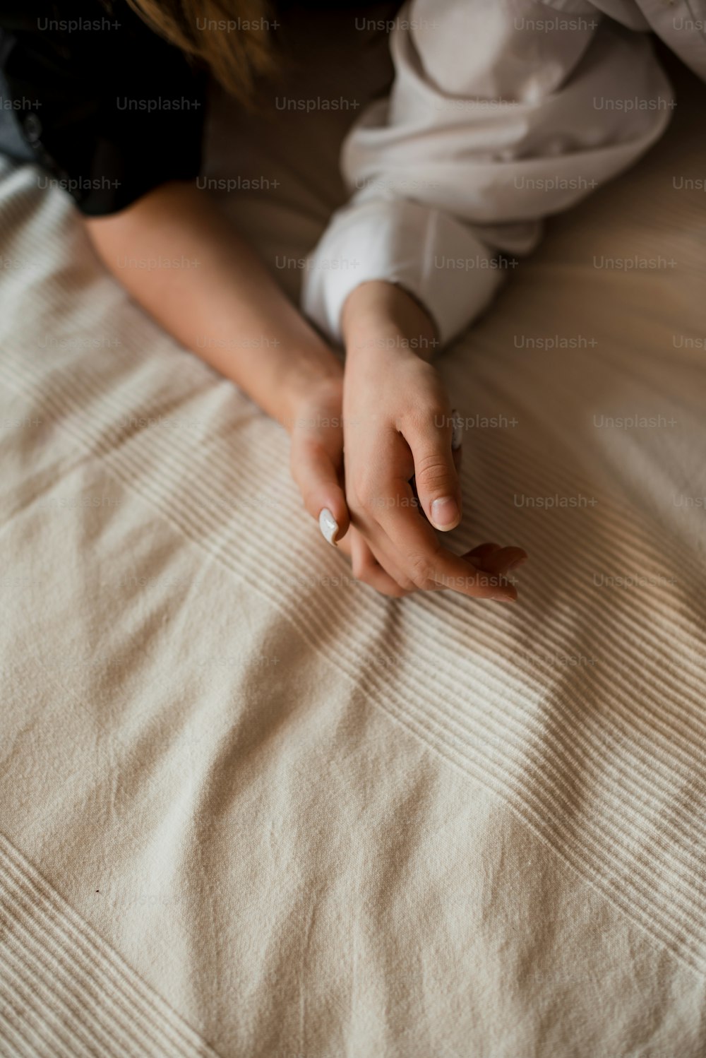 a woman laying on a bed with her hand on the pillow