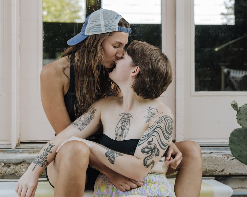 a woman sitting on a bench kissing a boy