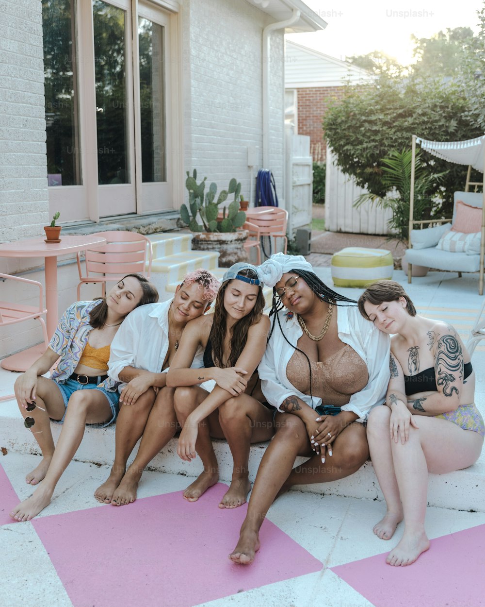 a group of women sitting on top of a pink and white checkered floor