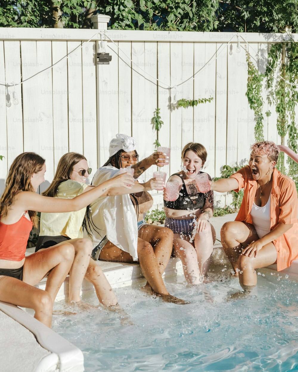um grupo de moças sentadas em uma piscina de água