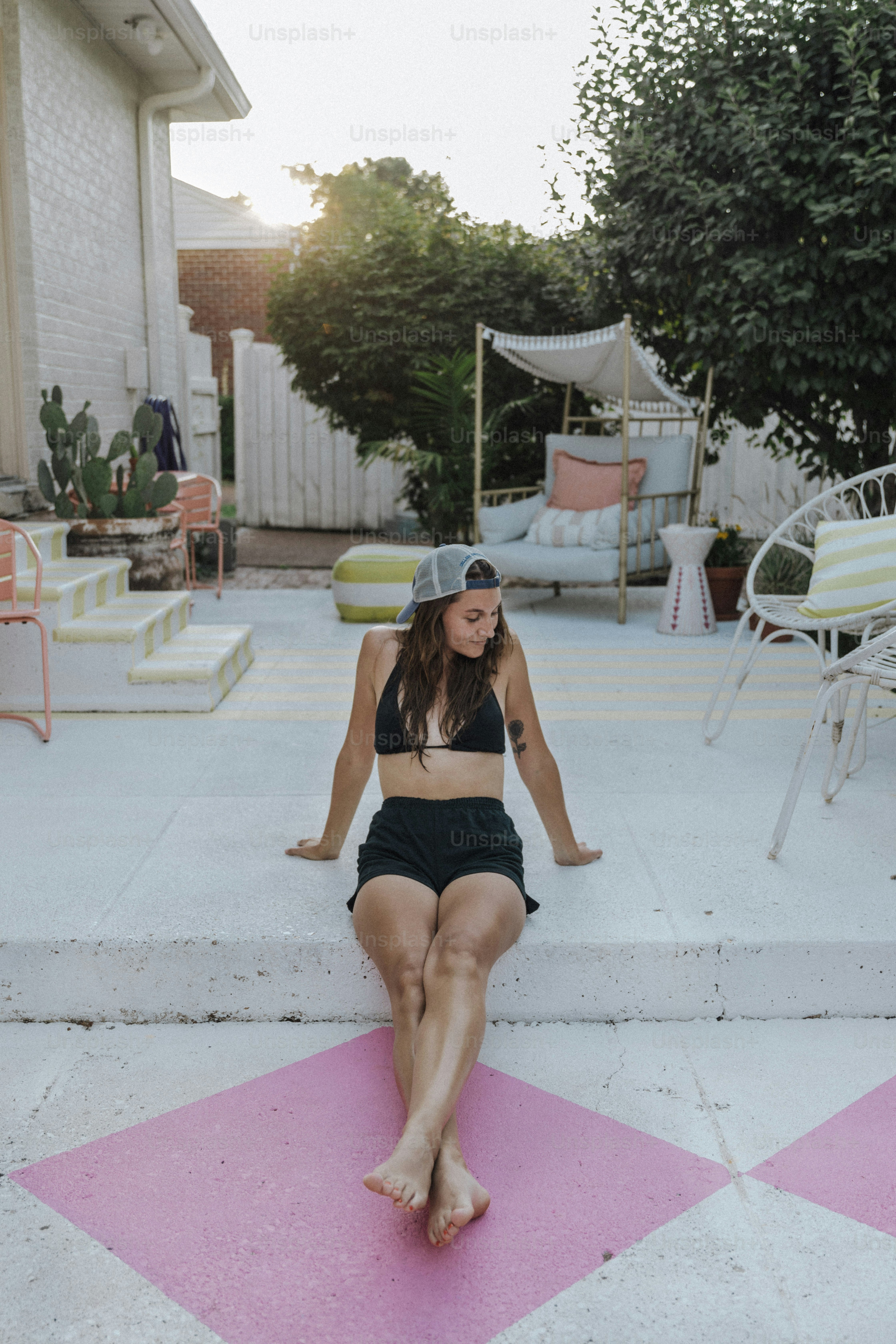 a woman in a bikini sitting on the steps of a house