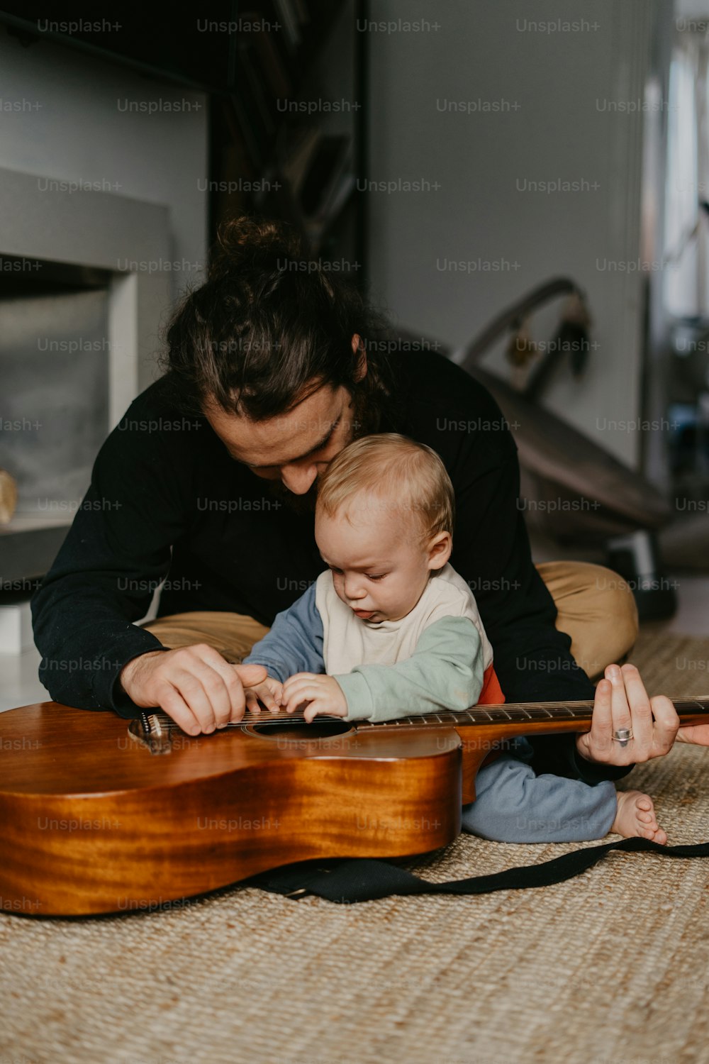 a man and a baby playing with a guitar