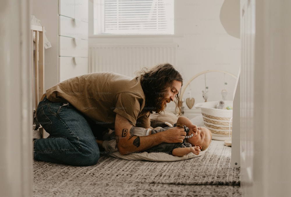 a man holding a baby on the floor