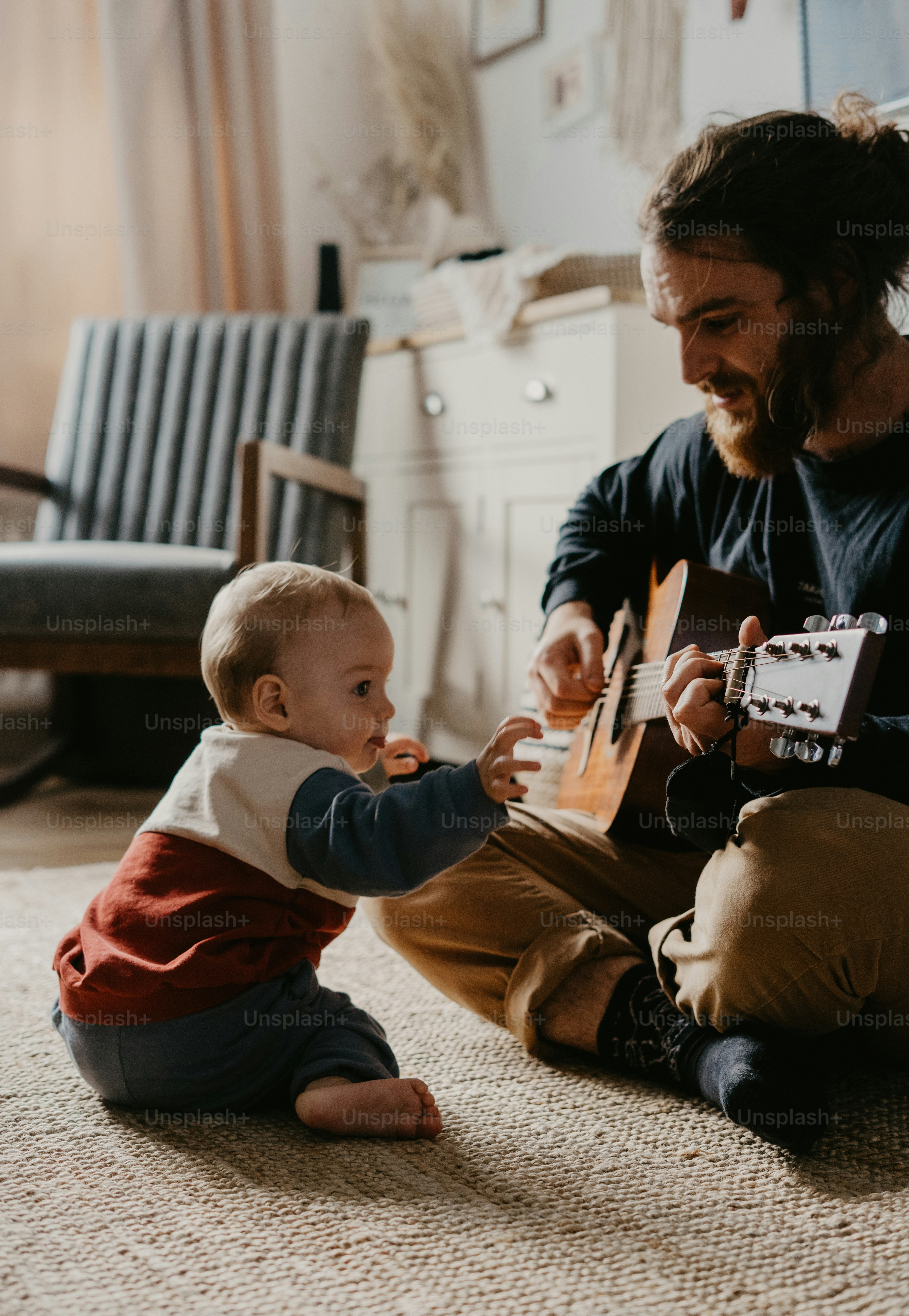 a man playing with a baby on the floor