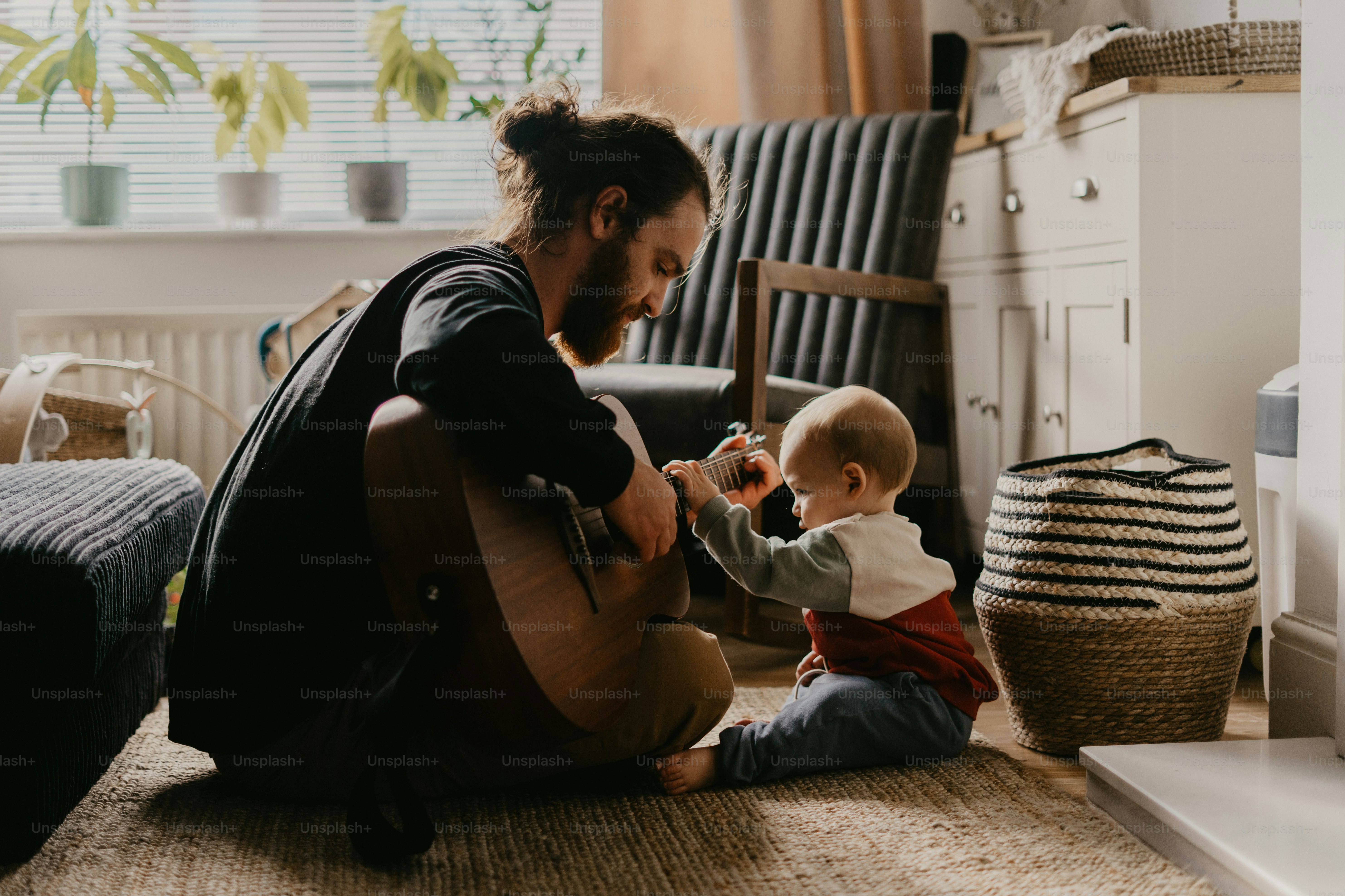 a man sitting on the floor playing with a baby