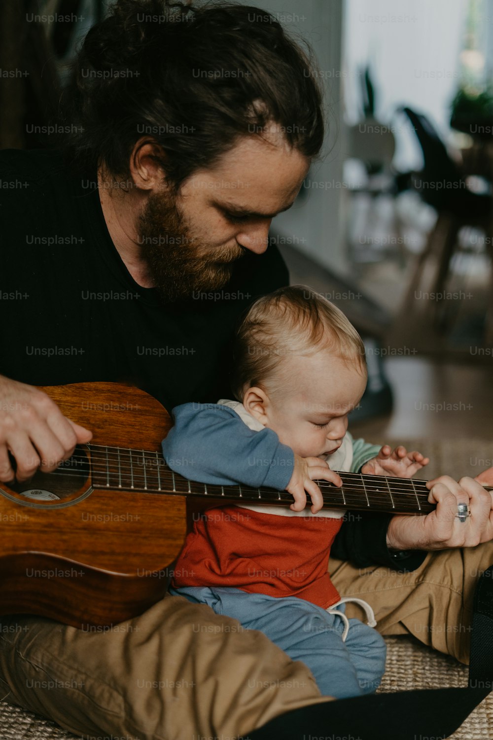 Un uomo che suona una chitarra con un bambino