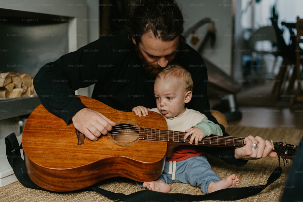 a man playing a guitar with a baby