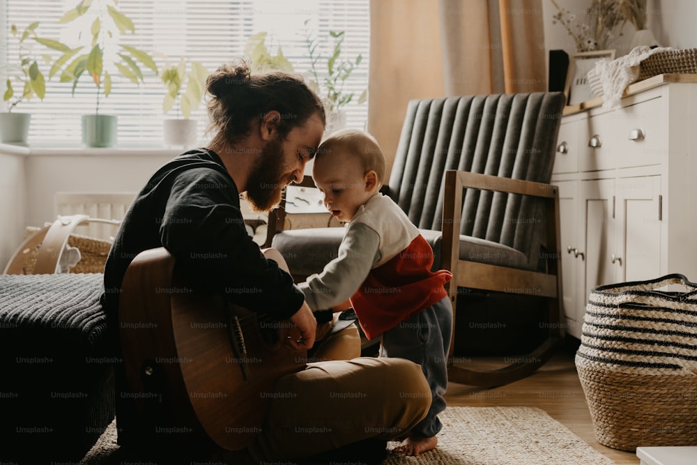 a man playing with a baby on the floor