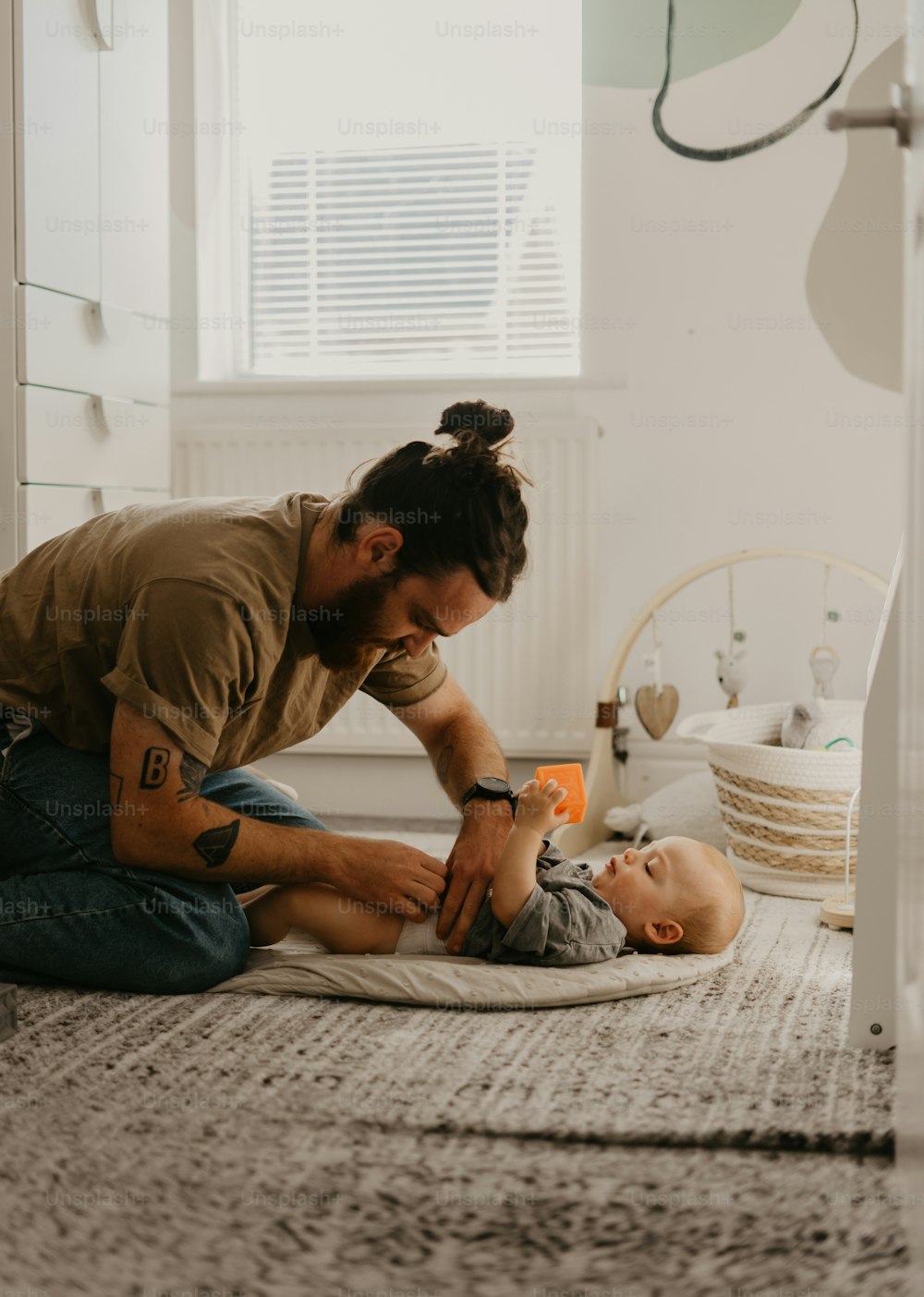 a man is playing with a baby on the floor
