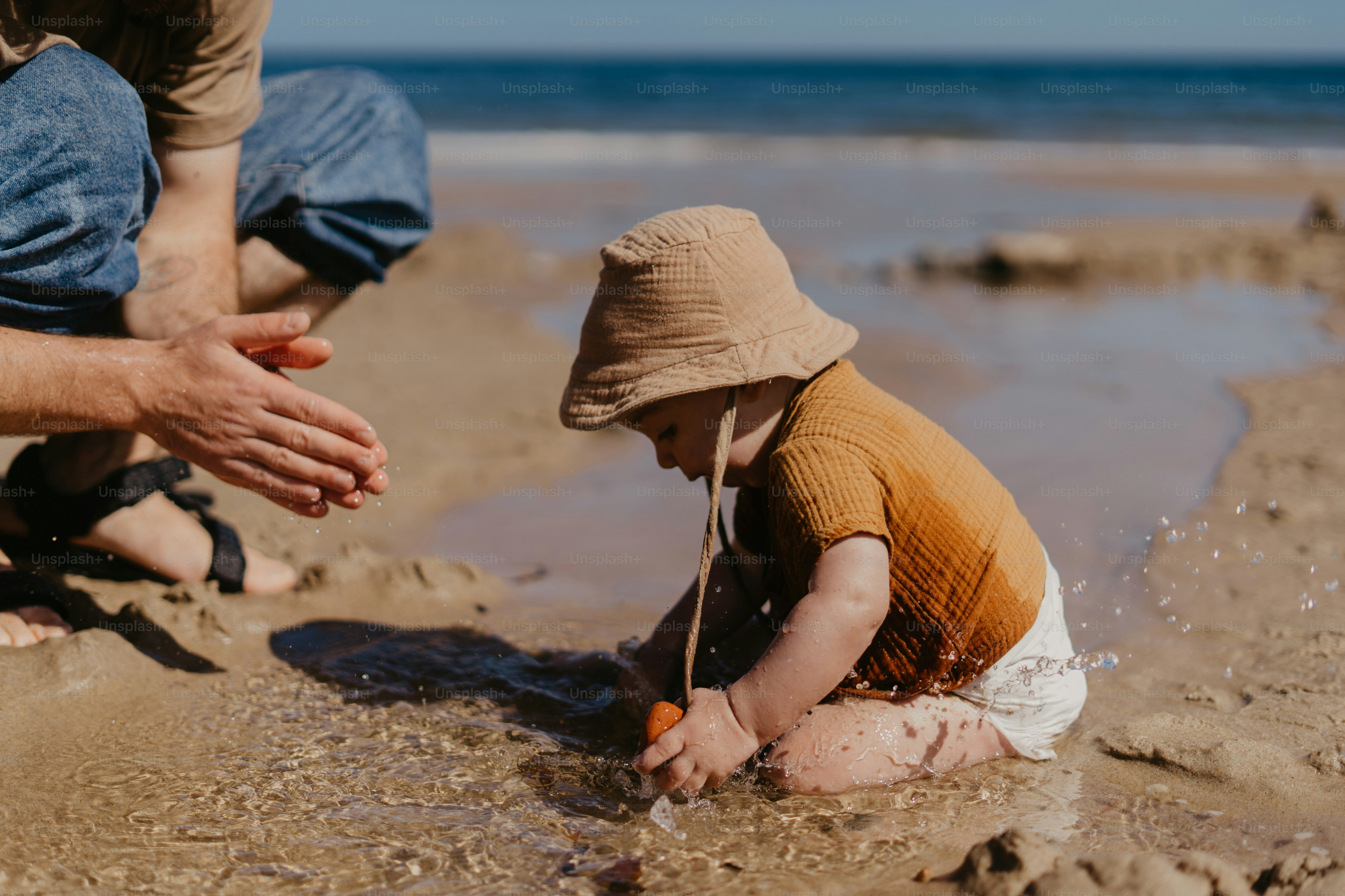 a little boy playing in the sand at the beach