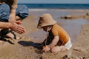 a little boy playing in the sand at the beach