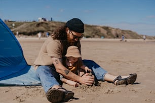 a man and a child playing in the sand