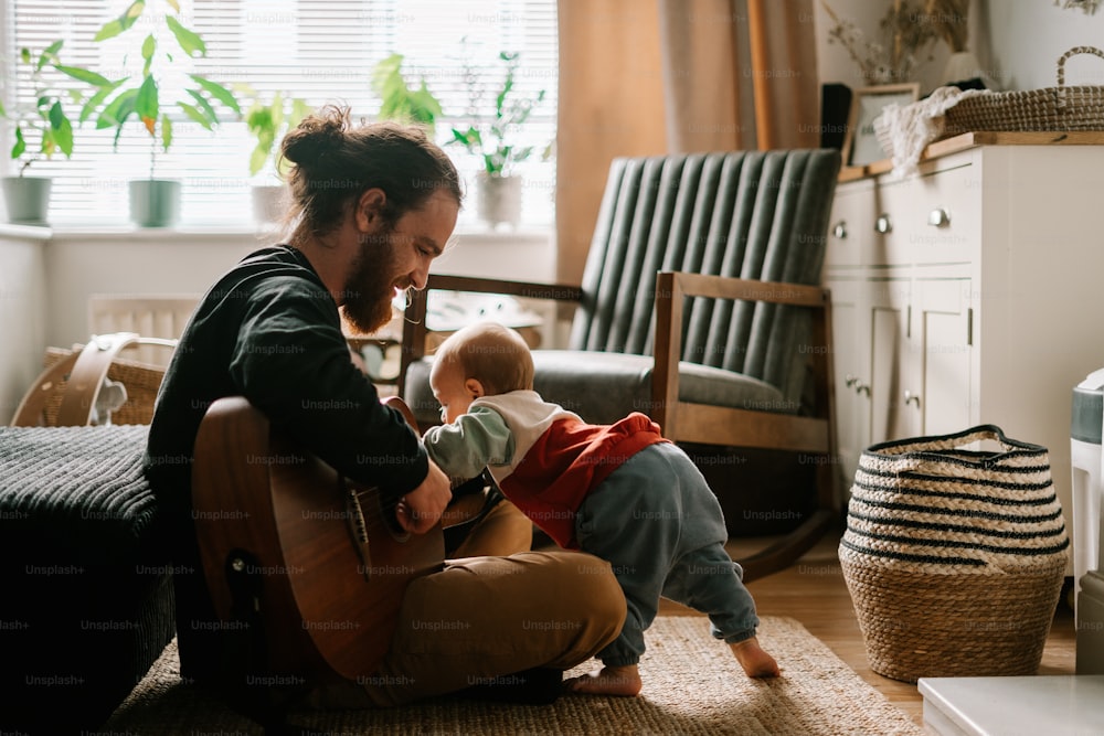 a man playing with a baby on the floor