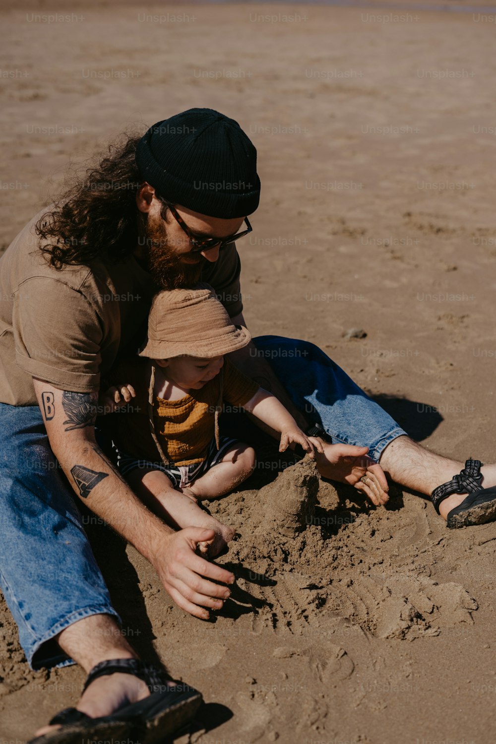 a man and a child playing in the sand