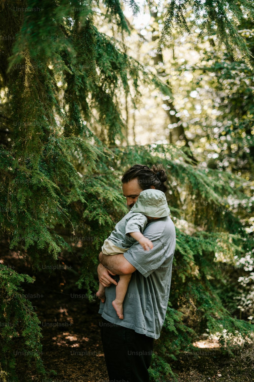 a woman holding a baby in a forest