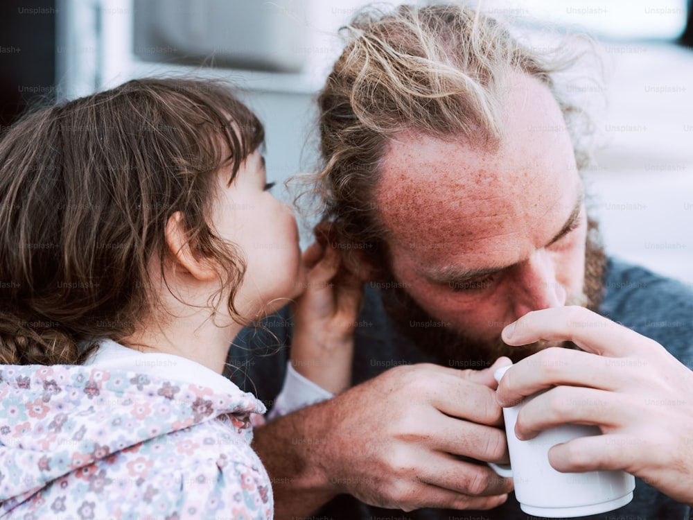 Un homme et une petite fille buvant du café