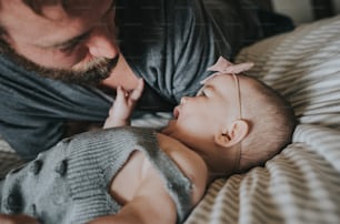 a man holding a baby on top of a bed