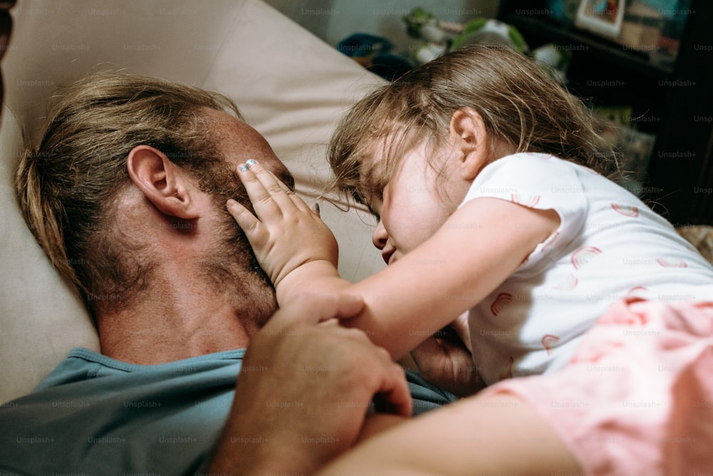 a man laying in bed with a little girl