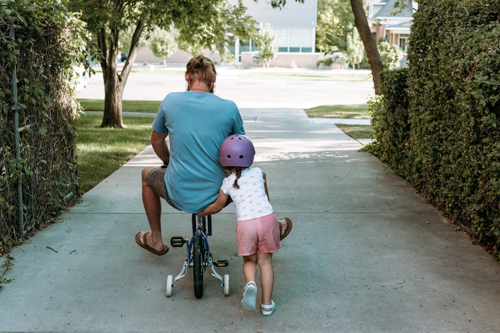 un homme à vélo avec une petite fille dessus