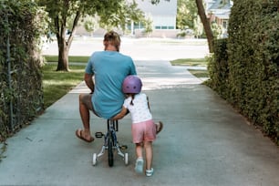 a man riding a bike with a little girl on it