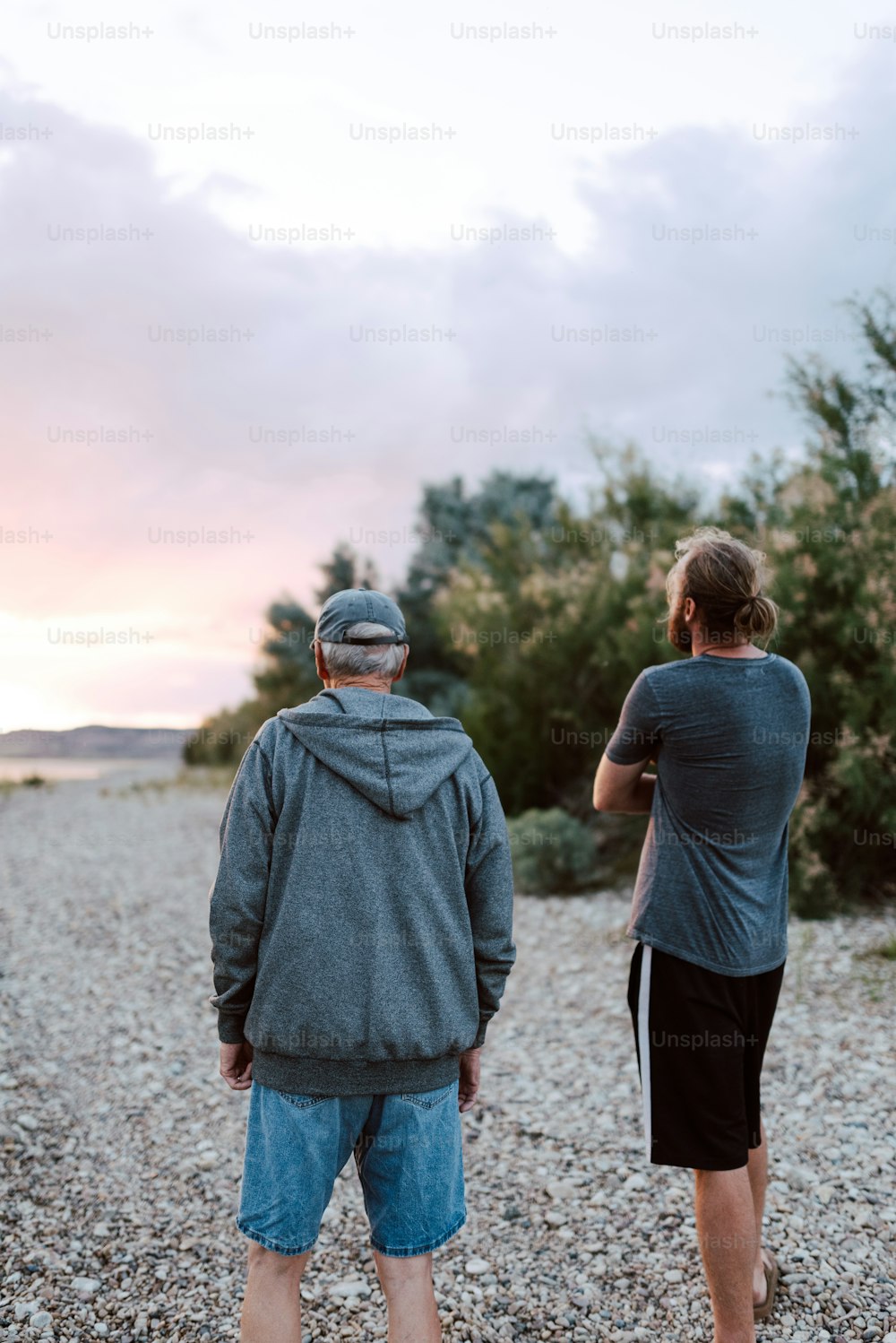 a man and a woman standing on a gravel road