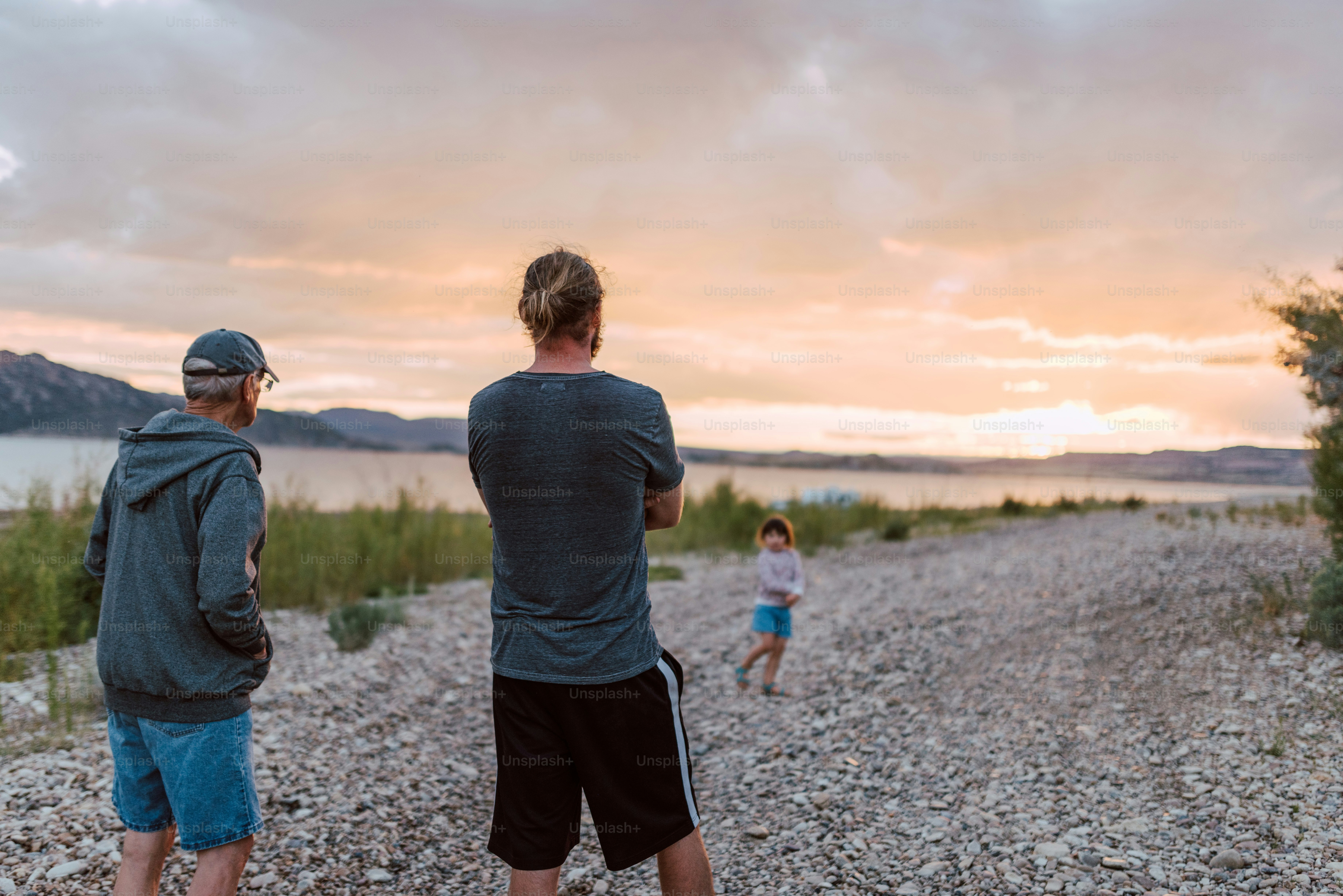 a couple of men standing on top of a gravel road
