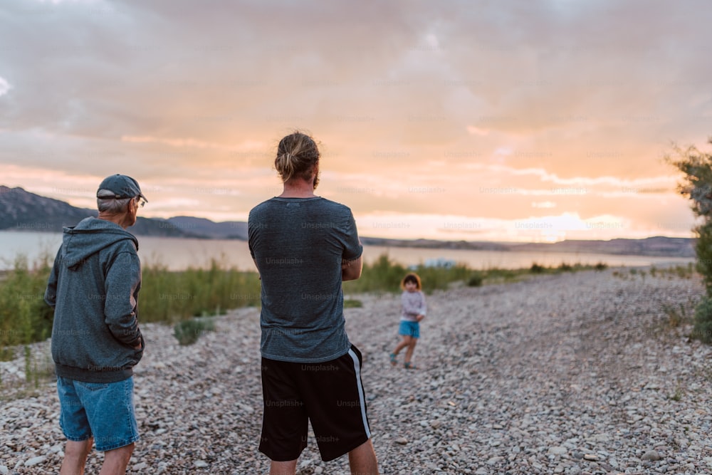 a couple of men standing on top of a gravel road