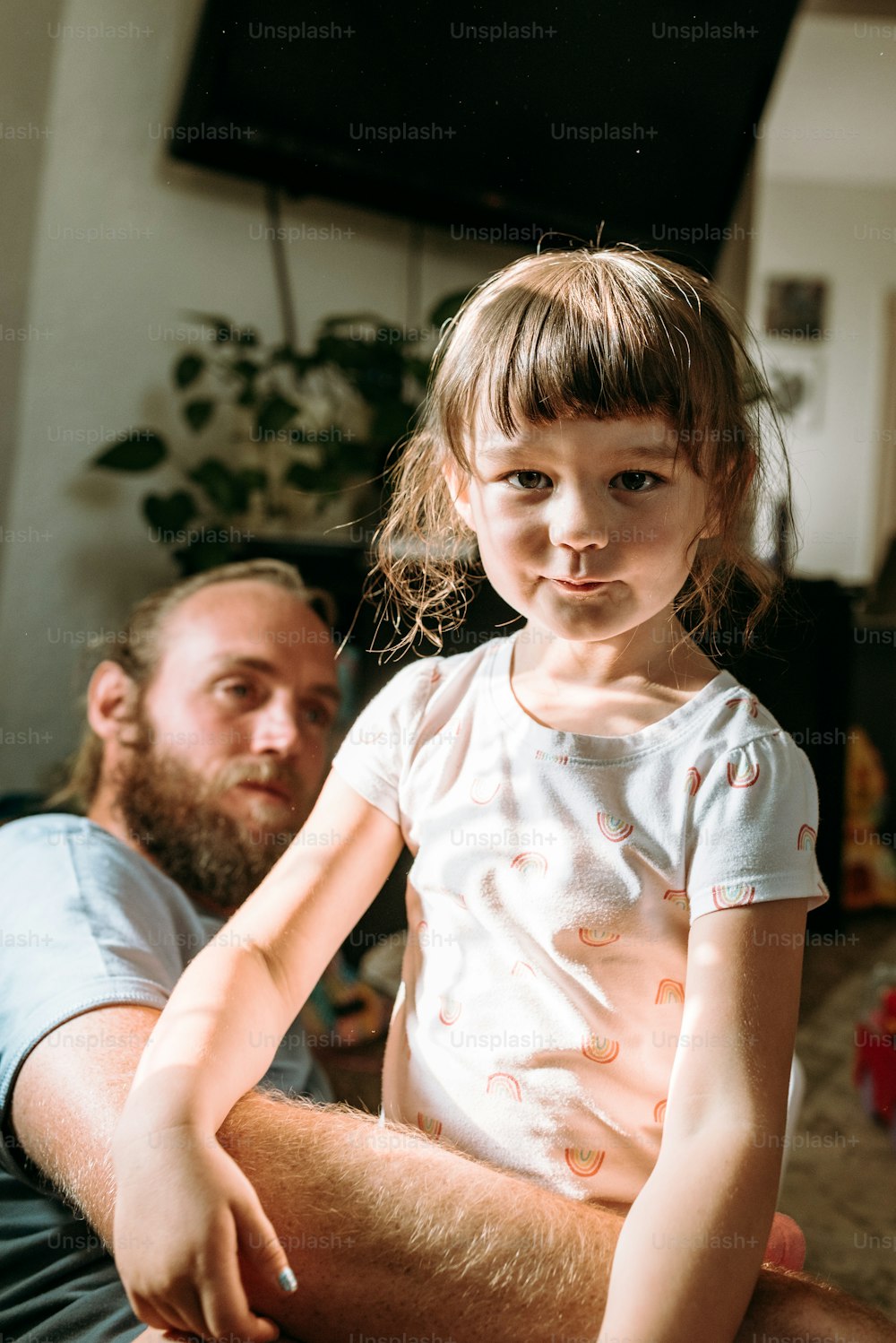 a man sitting next to a little girl on a couch