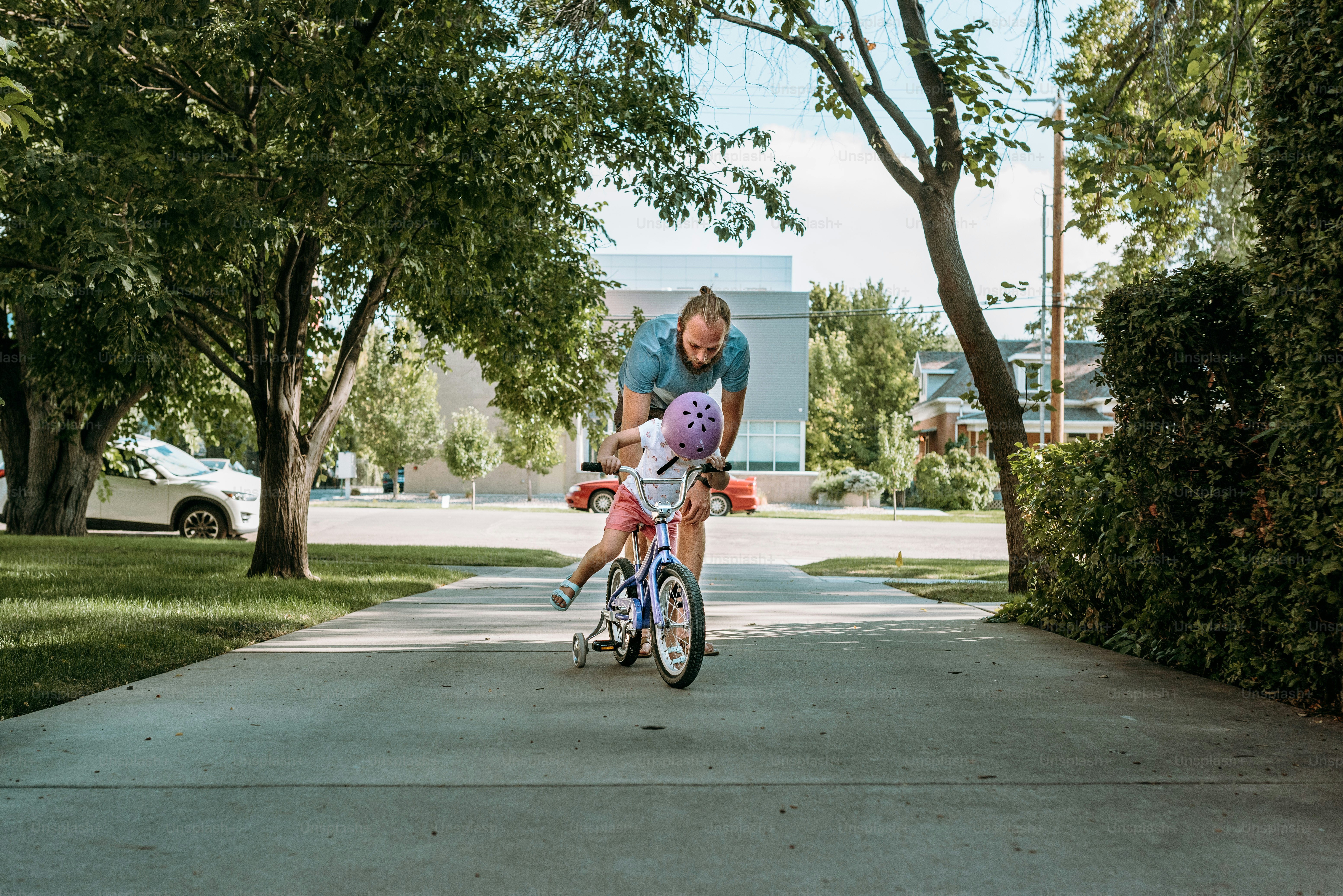 a woman riding a bike down a sidewalk