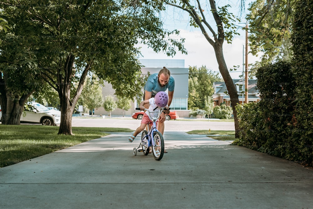 a woman riding a bike down a sidewalk
