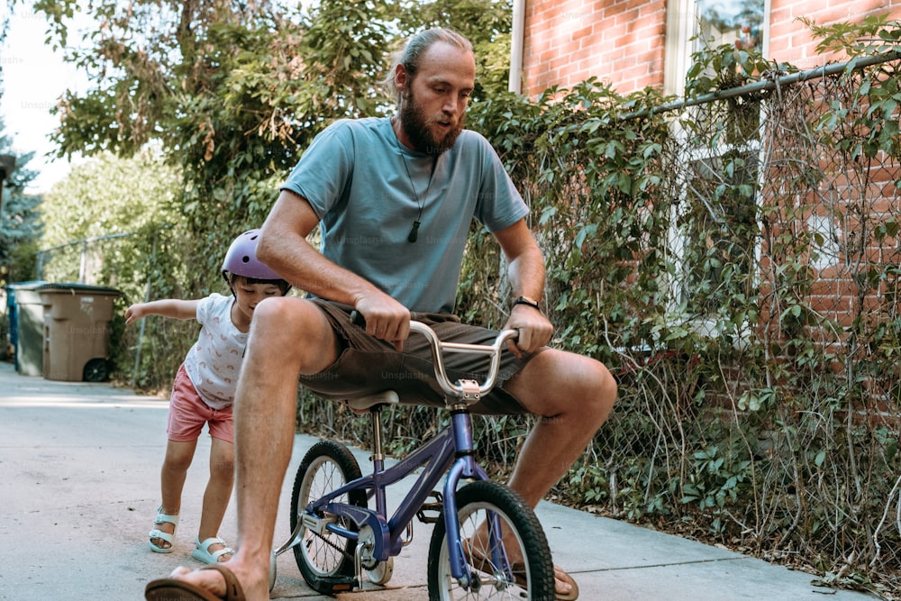 Un uomo che va in bicicletta accanto a una bambina