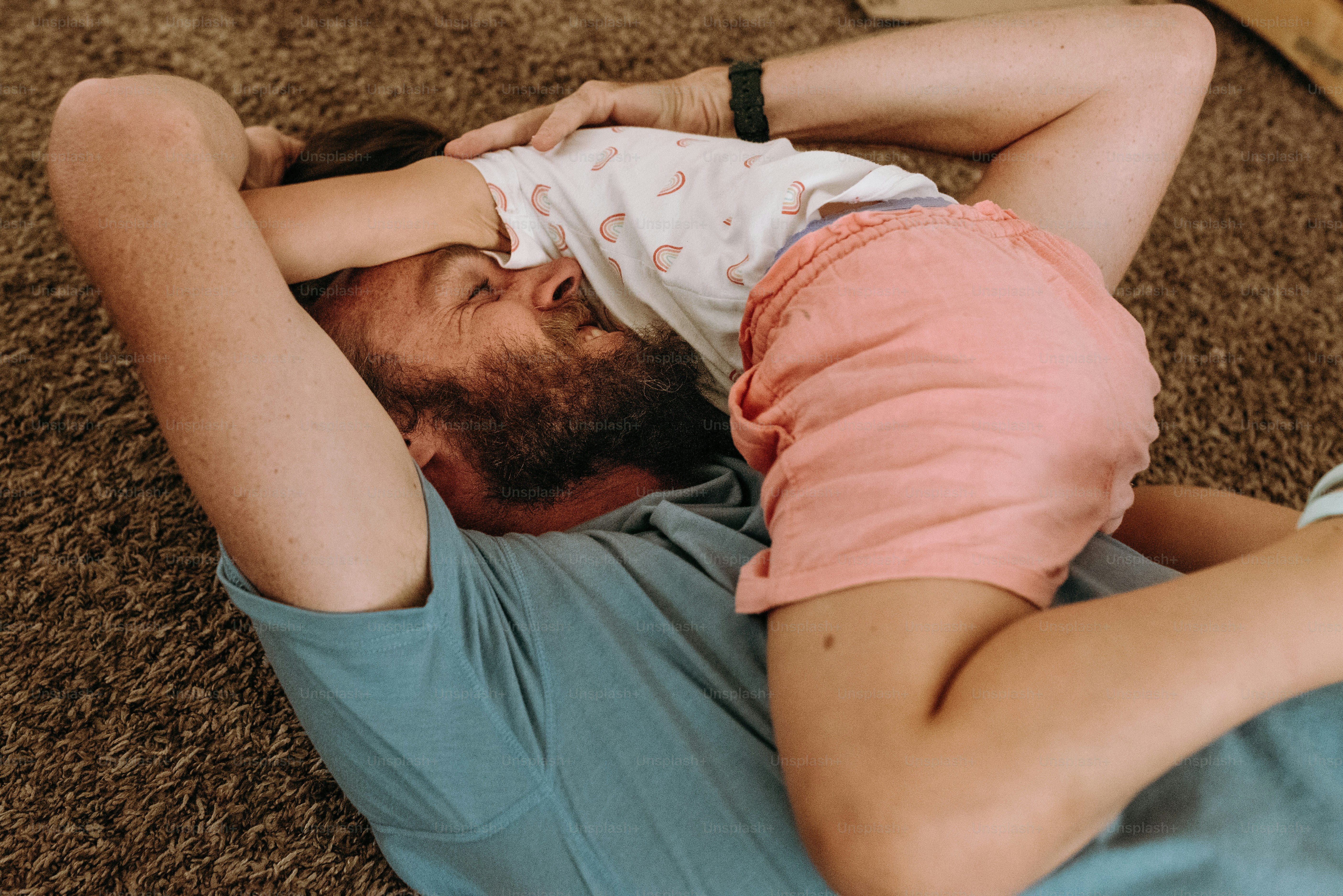 a man laying on the floor holding a baby