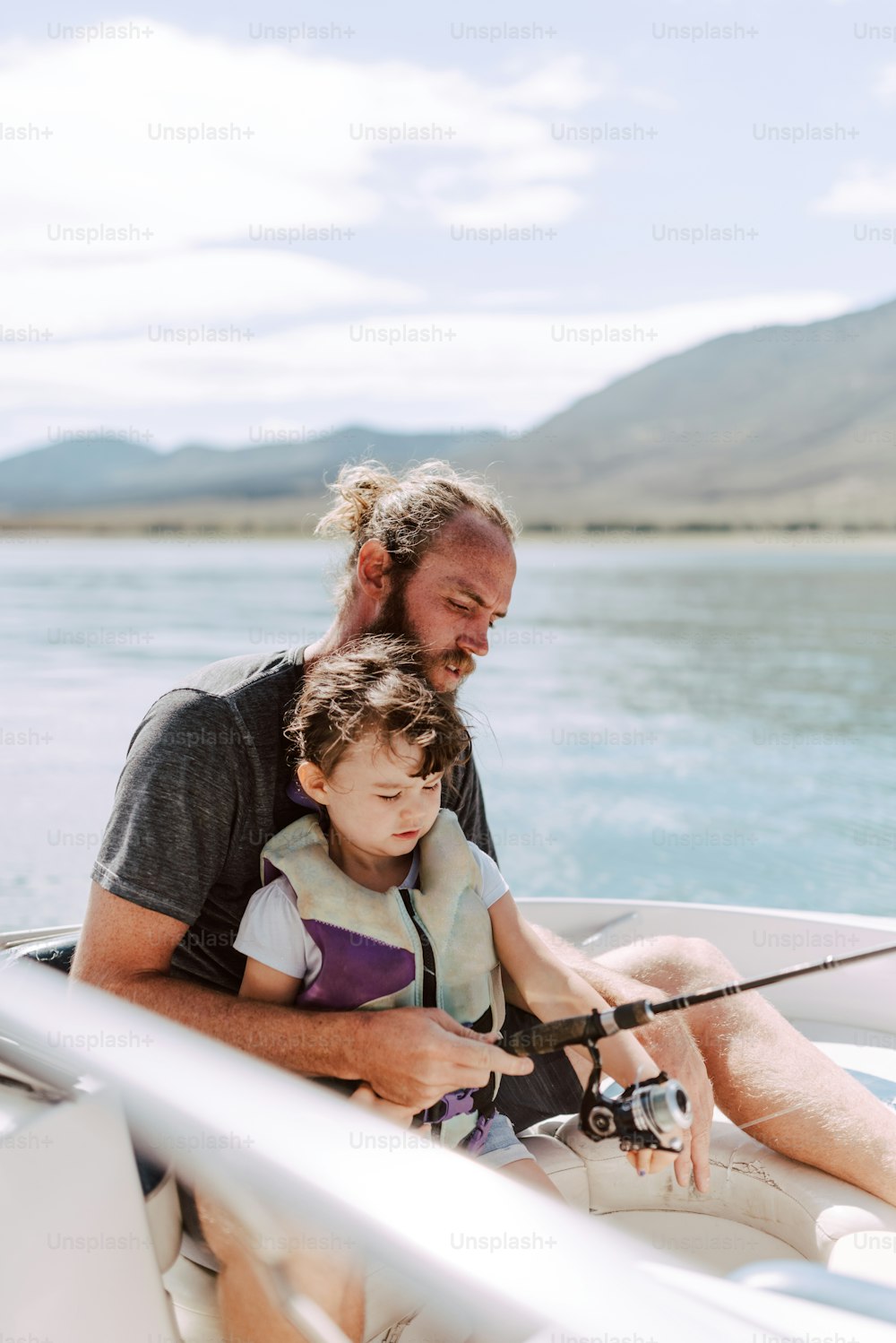 Un uomo e una bambina che pescano su una barca
