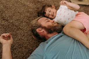 a man and a little girl laying on the floor
