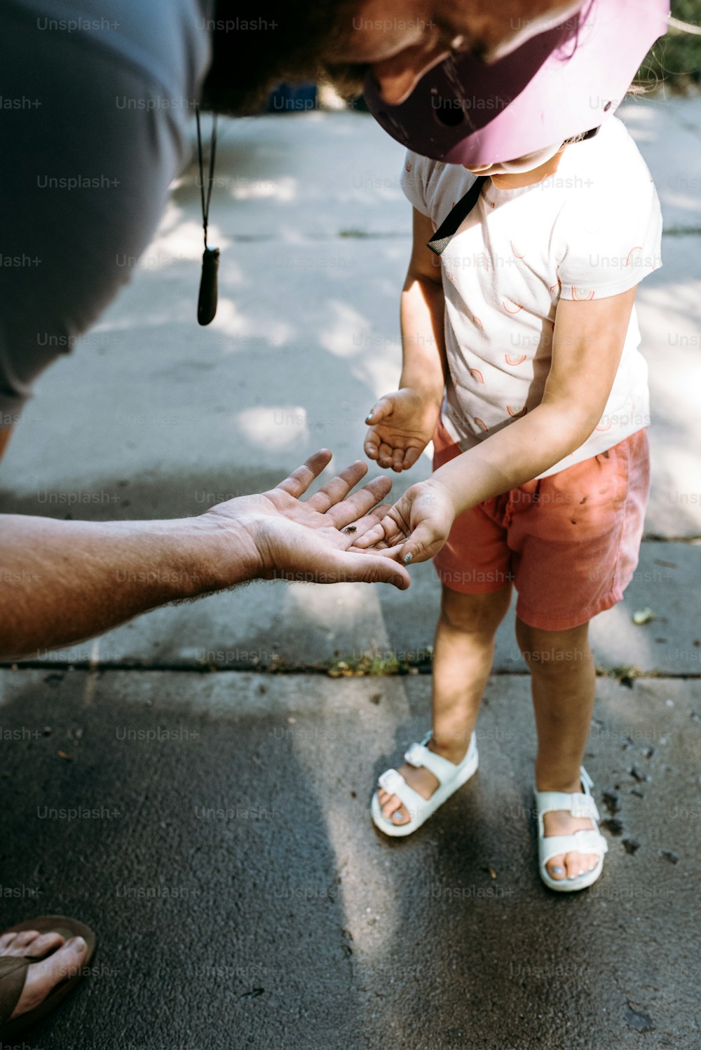 a small child reaching out to a man's hand