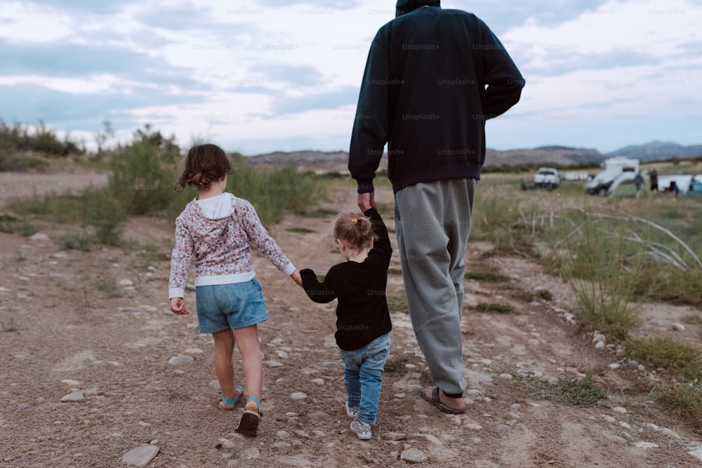 Un hombre y una niña caminando por un camino de tierra