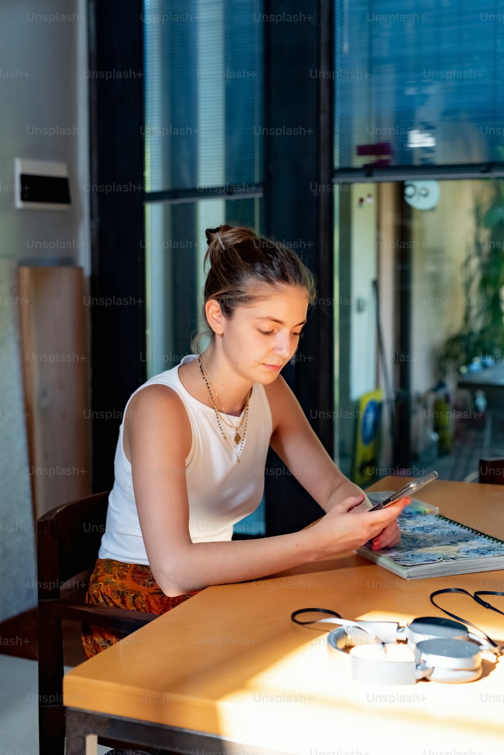 Una mujer sentada en una mesa mirando una revista