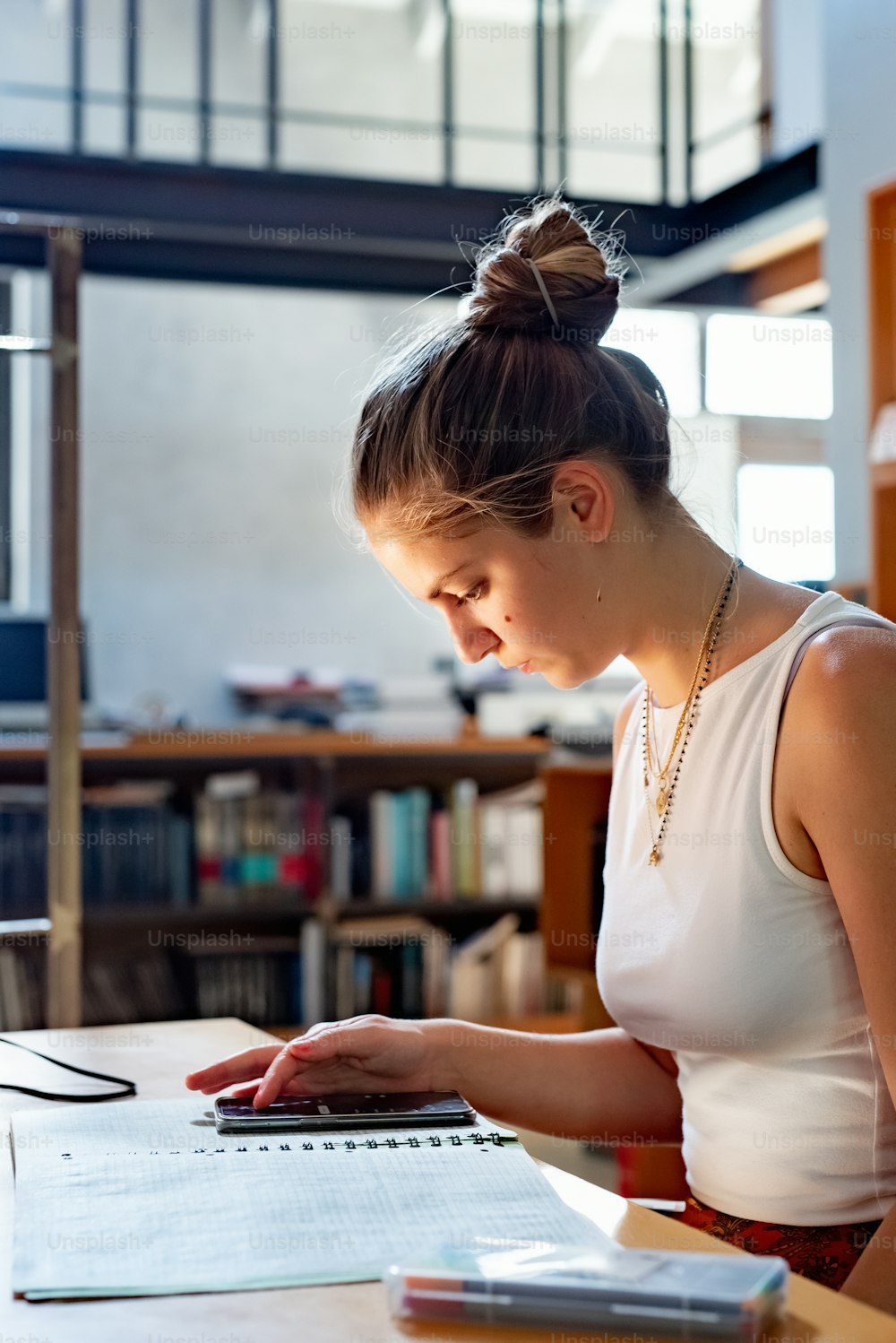 a woman sitting at a table working on a laptop