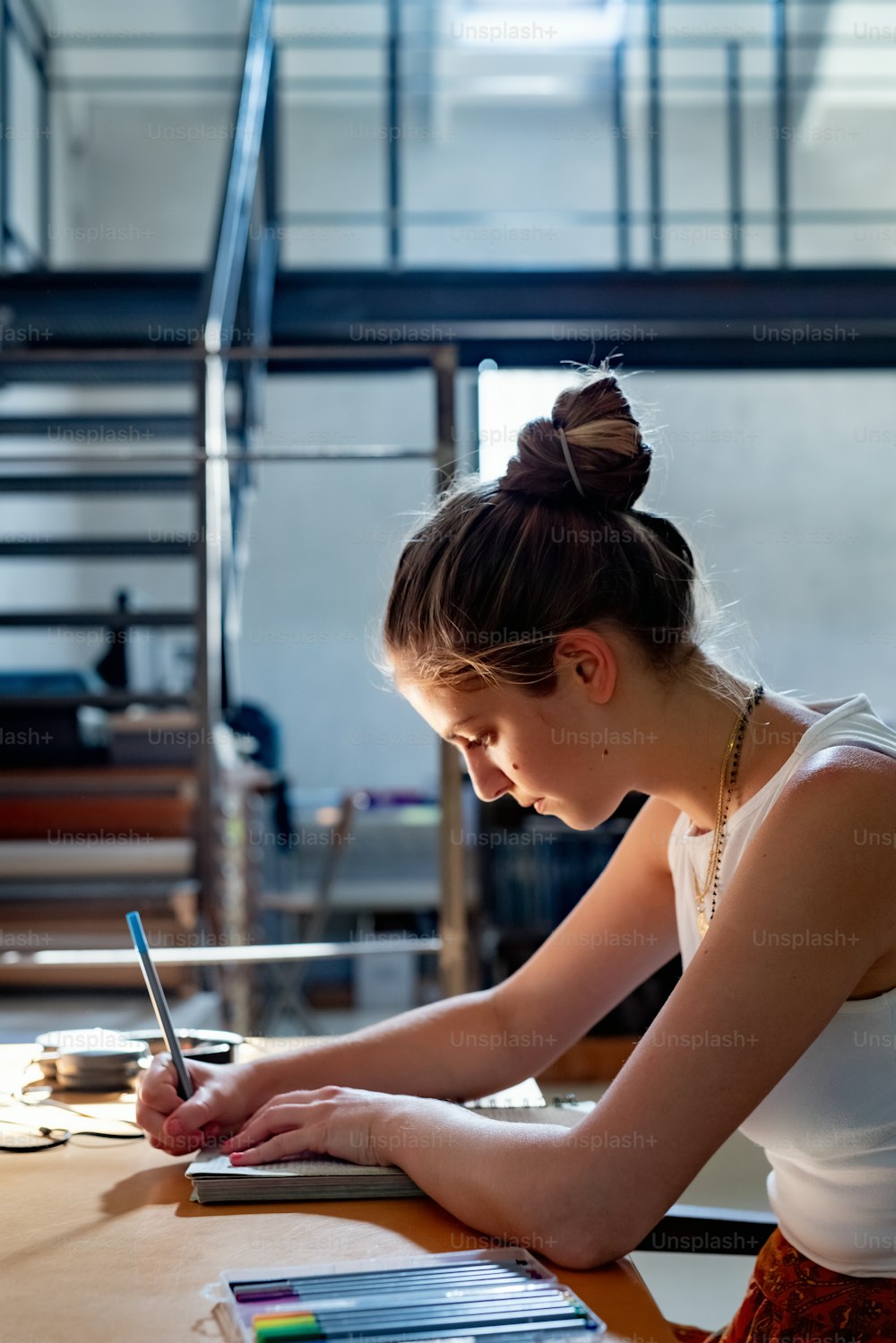 Una mujer sentada en una mesa escribiendo en un cuaderno