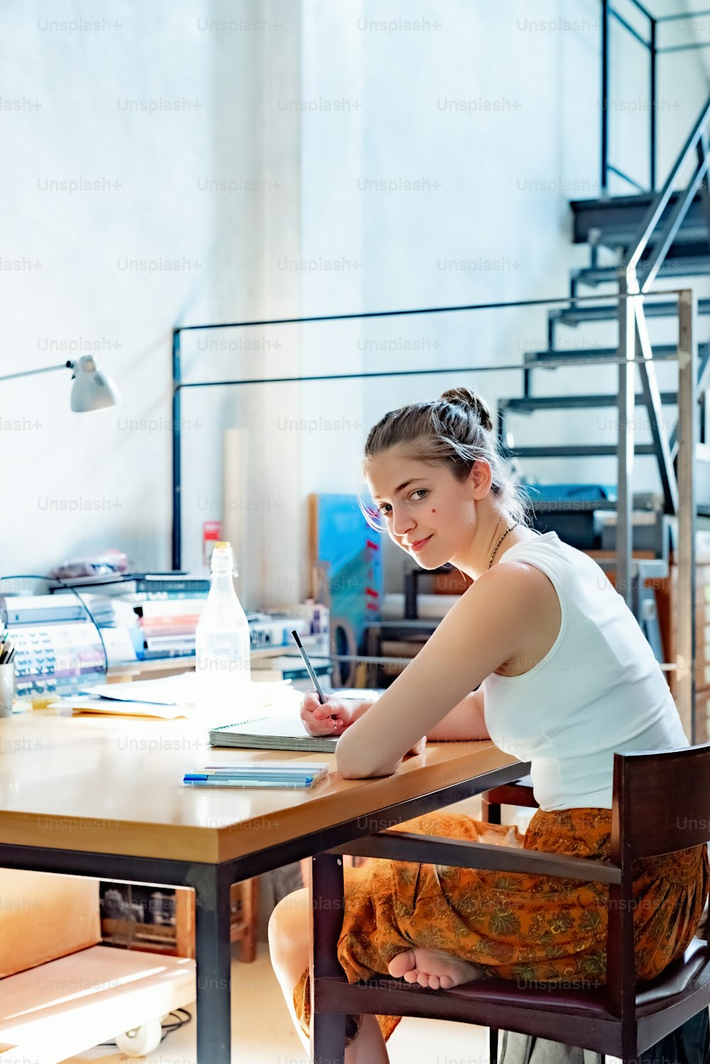 Una mujer sentada en una mesa con una computadora portátil