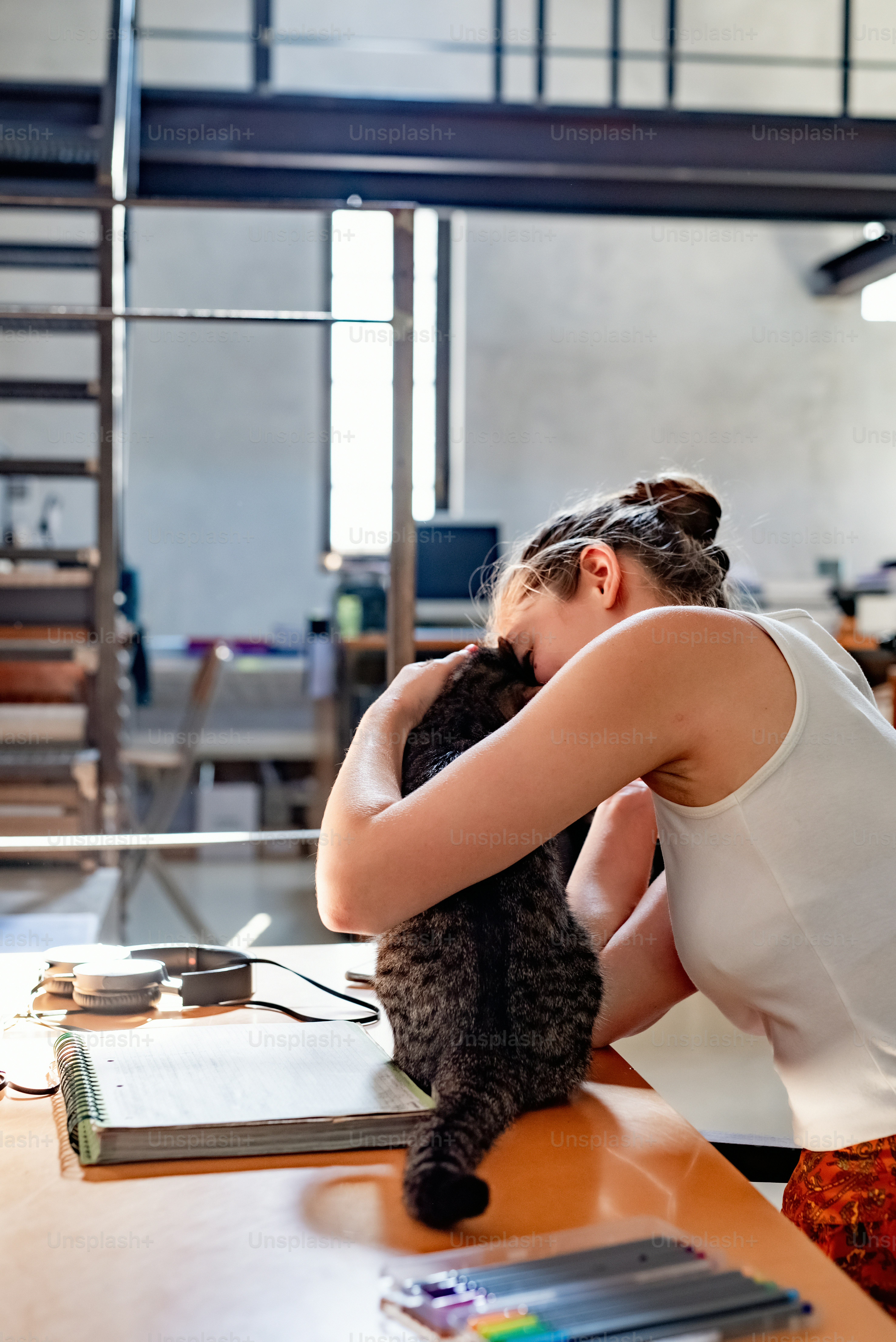 a woman sitting at a table with a cat