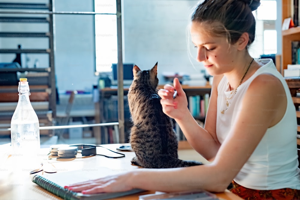 Una mujer sentada en una mesa con un gato