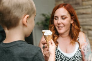 una donna che tiene un cono gelato a un ragazzo