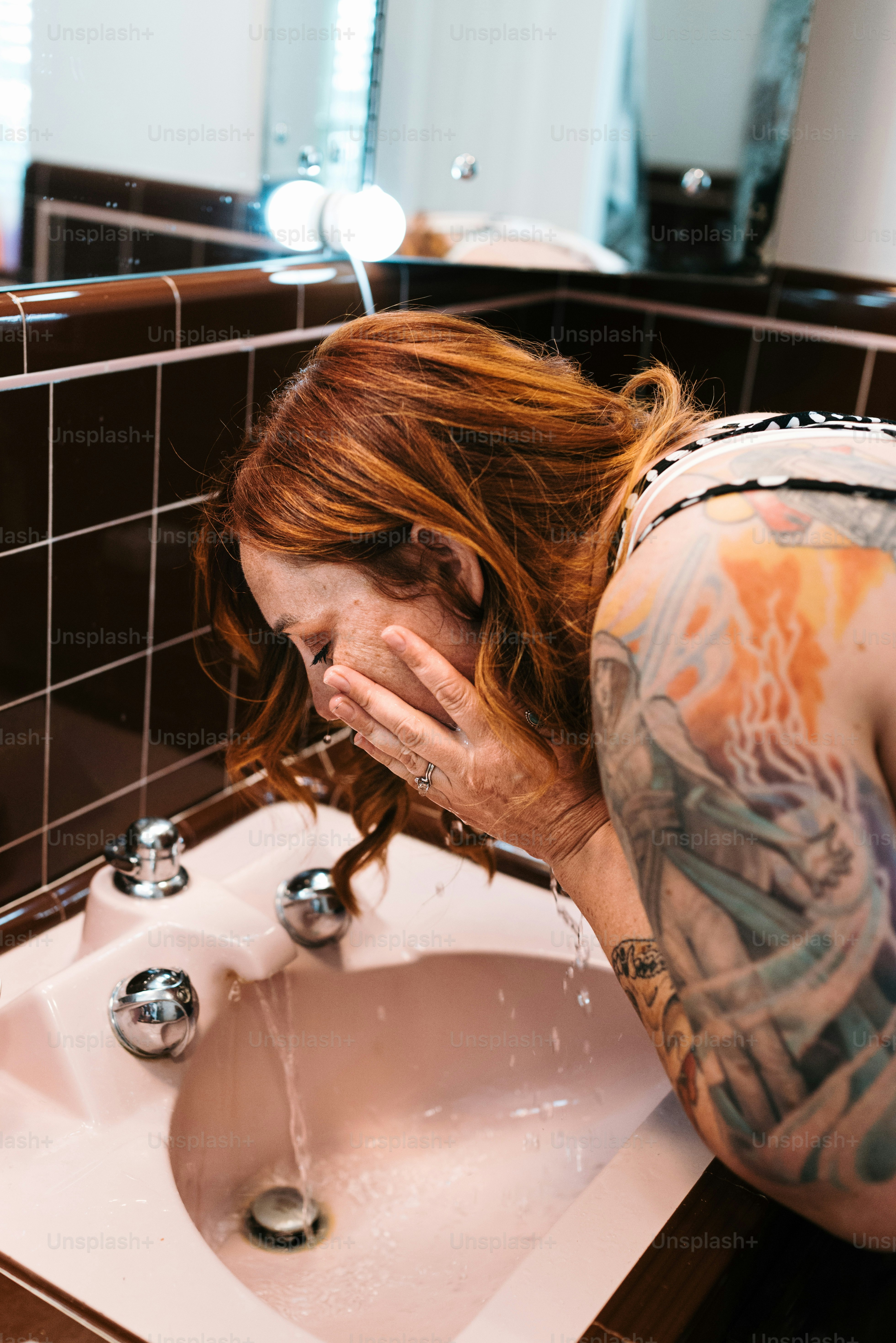 a woman with her head in her hands in front of a sink