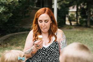 Une femme aux cheveux roux tenant un cupcake dans ses mains