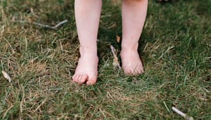un gros plan des pieds nus d’une personne dans l’herbe