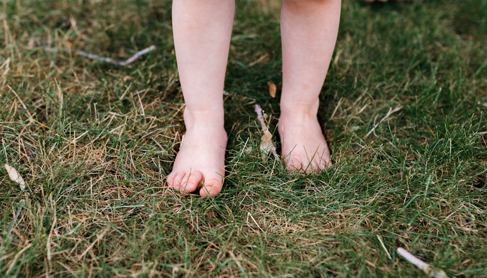 a close up of a person's bare feet in the grass