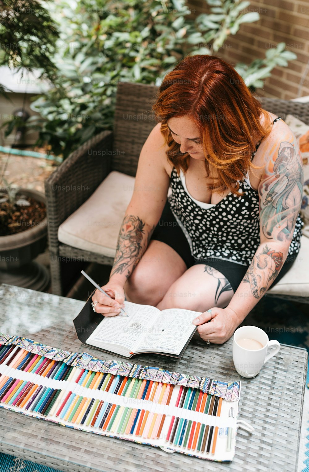 a woman sitting on a patio reading a book