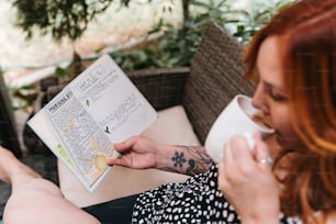 a woman sitting on a couch reading a book