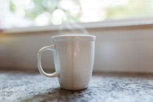 a white coffee cup sitting on top of a counter